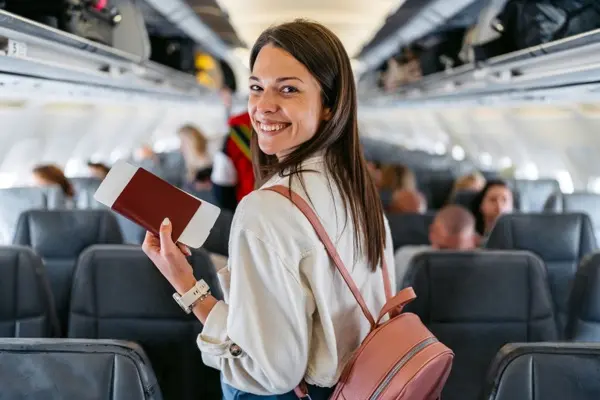Portrait of a beautiful young woman boarding an airplane in Austria finding her seat